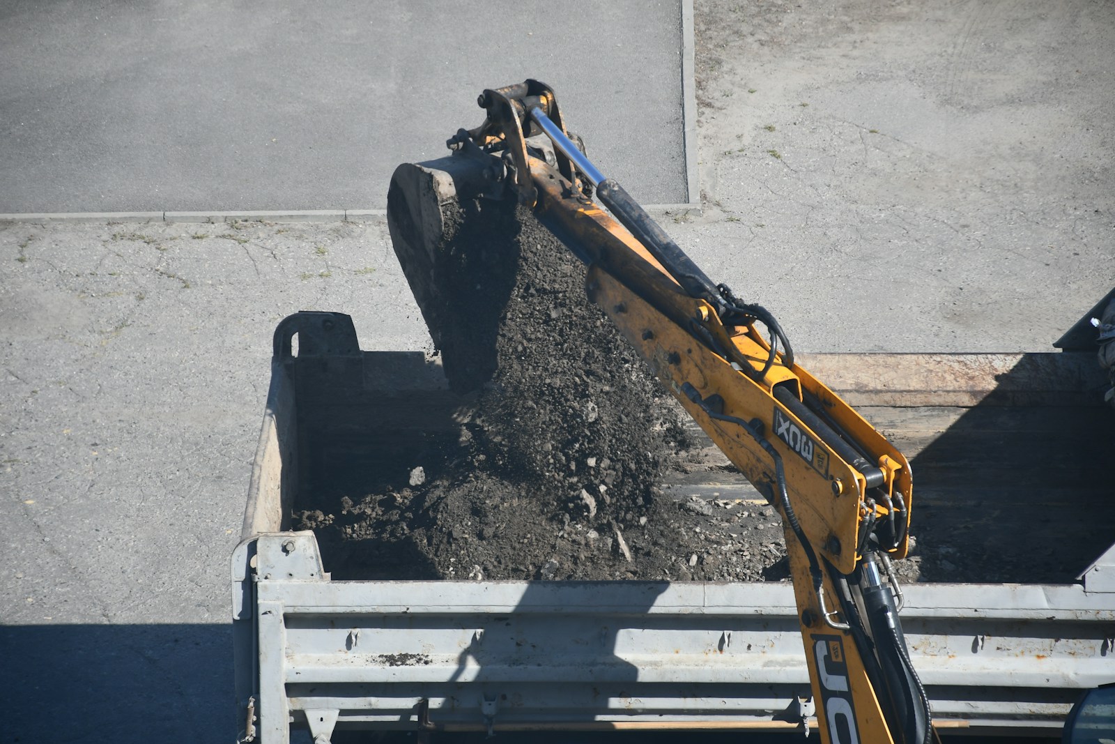 Excavator dumping dirt into a truck